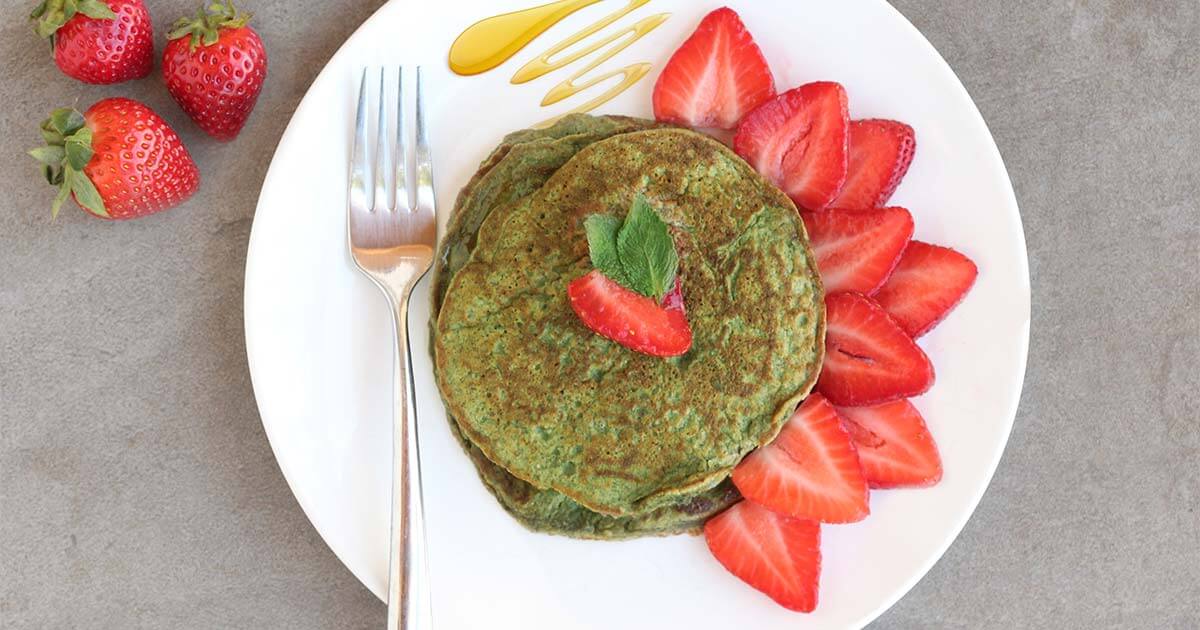 Green protein powder pancakes with strawberries